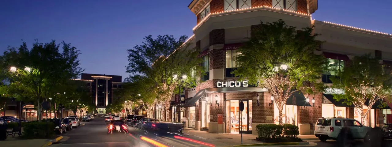 Shops and outdoor seating at Fairfax Corner after dark.