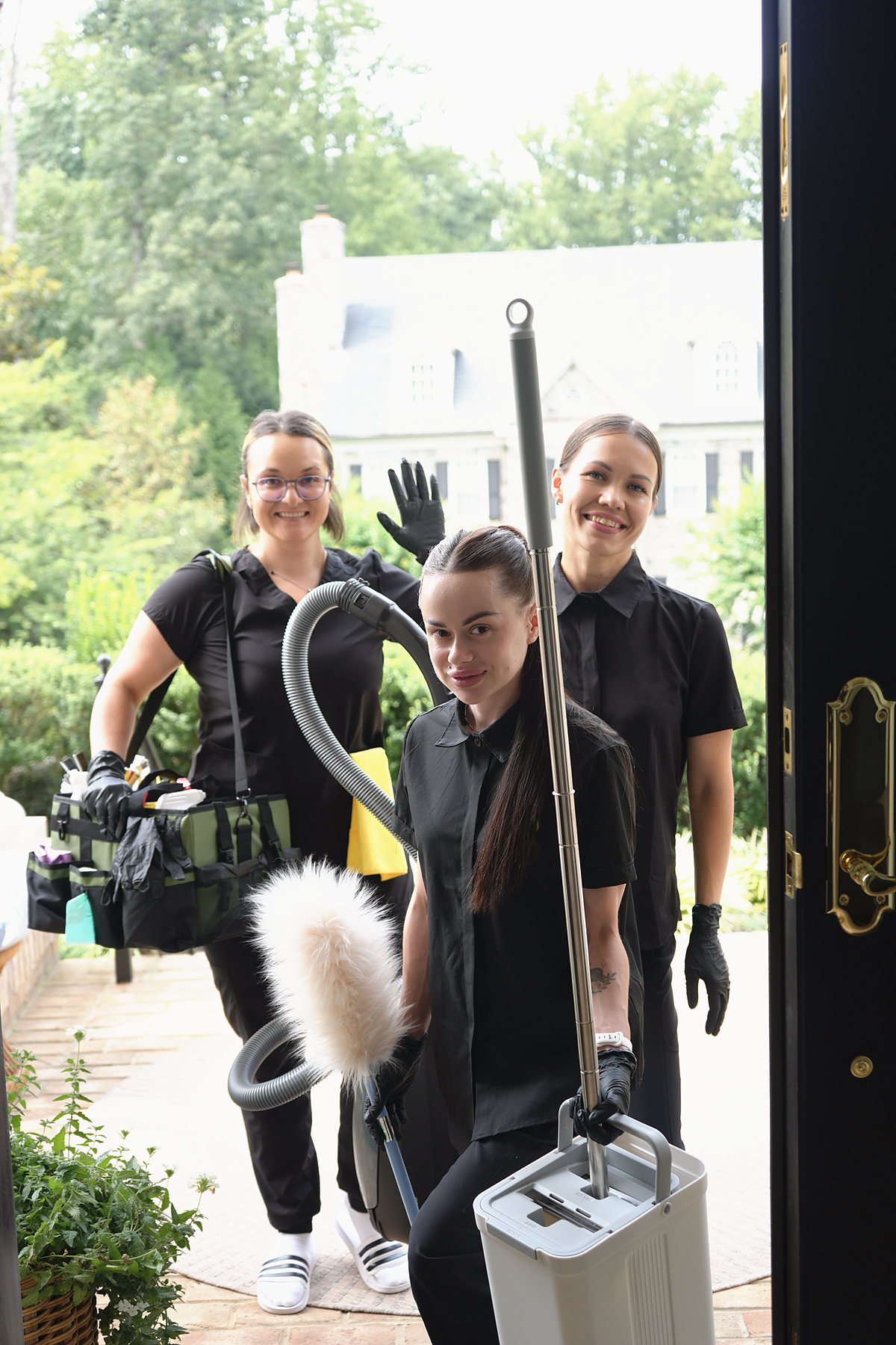 Three BroomStar cleaners arriving at a front door in Northern Virginia with their vacuum, caddy and mop